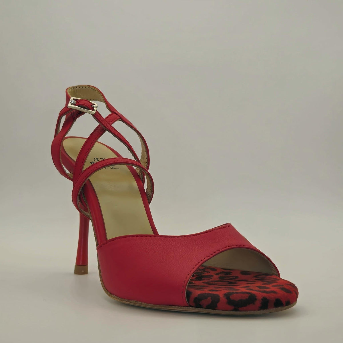 Three-quarter front view of Mono Rouge Desire women's tango sandal, showing bold leopard print toe cap and red leather wrap straps in close detail.