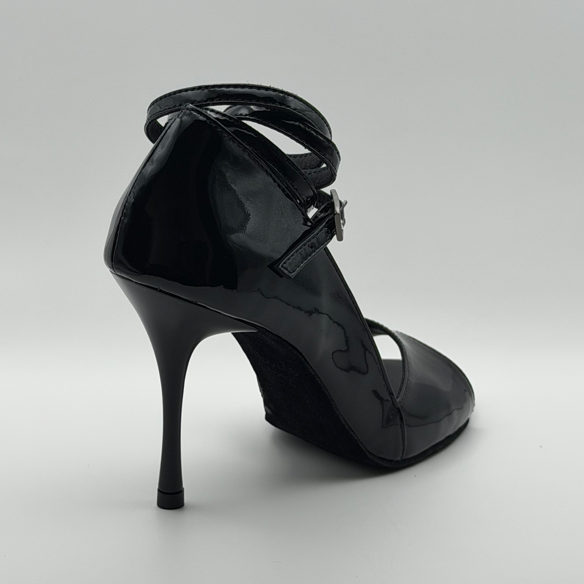 Back view of the Akvile Noir tango heel showing the glossy patent heel counter and the wrap strap crossing behind the ankle