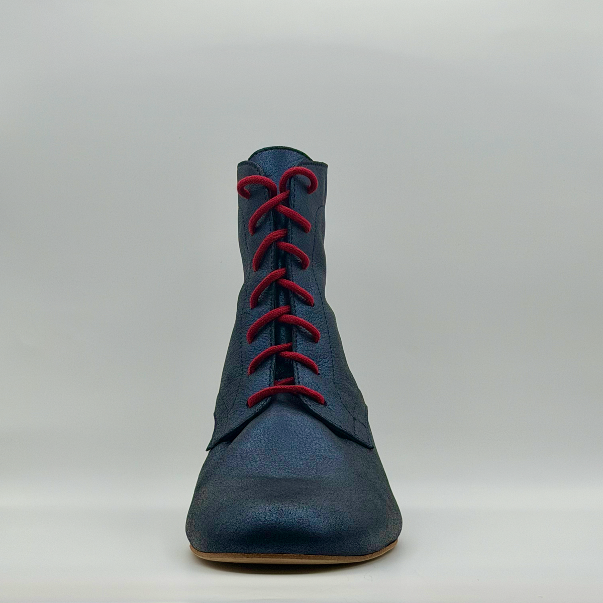 Front view of the Bleu Marine tango boot showing the red laces crossing up the instep and the burnished navy toe