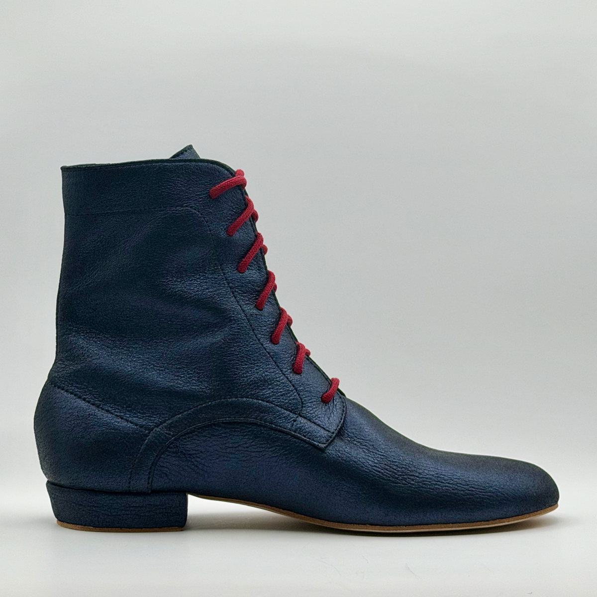 Side profile of the Mono Bleu Marine tango boot in crinkled navy leather, showing the red laces up the front, the curved heel overlay, and the low Cuban heel