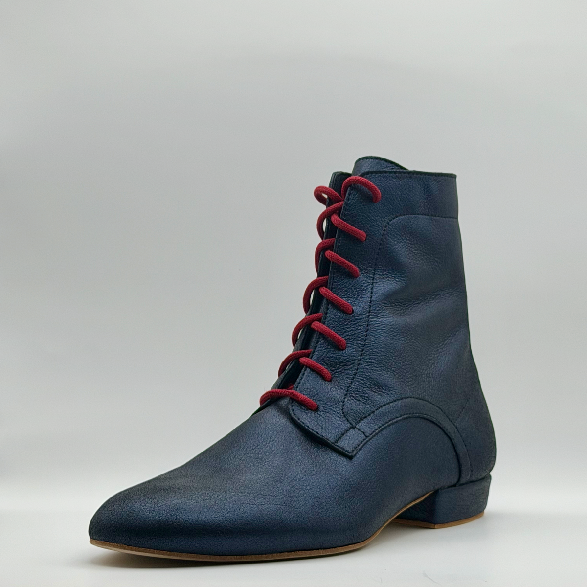 Three-quarter front view from the other side of the Bleu Marine tango boot, showing the laced front, the curved overlay, and the low Cuban heel