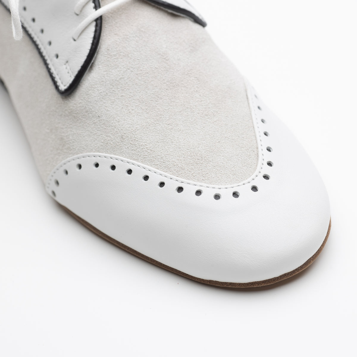 Close-up toe detail of Mono El Dandy men's tango Derby from a lower angle, showing the full brogue perforation wingtip, white smooth leather toe cap, cream suede inlay, and natural tan suede outsole.