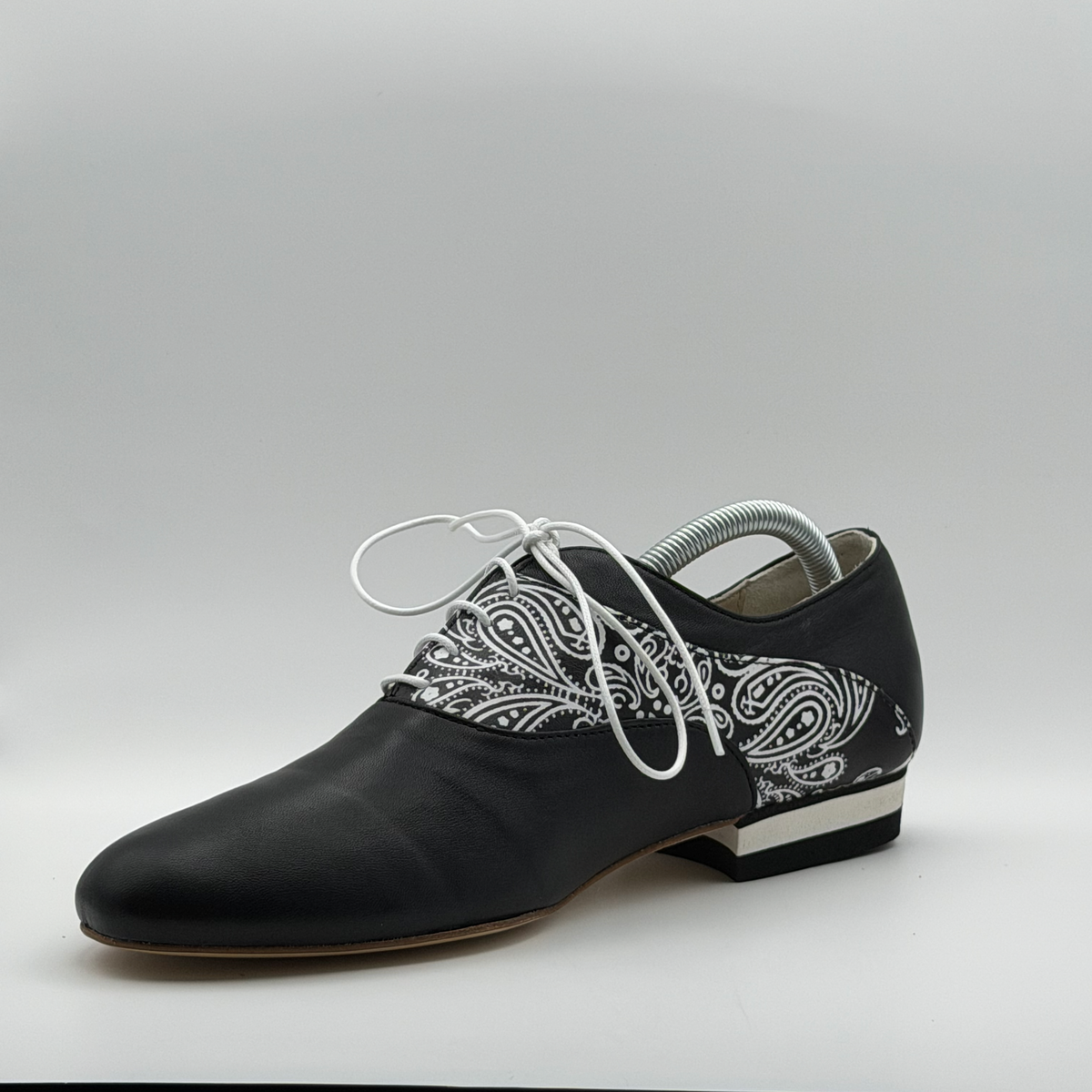 Three-quarter front view of the Mono El Pañuelo tango oxford from the opposite side, showing the paisley print wrapping toward the heel