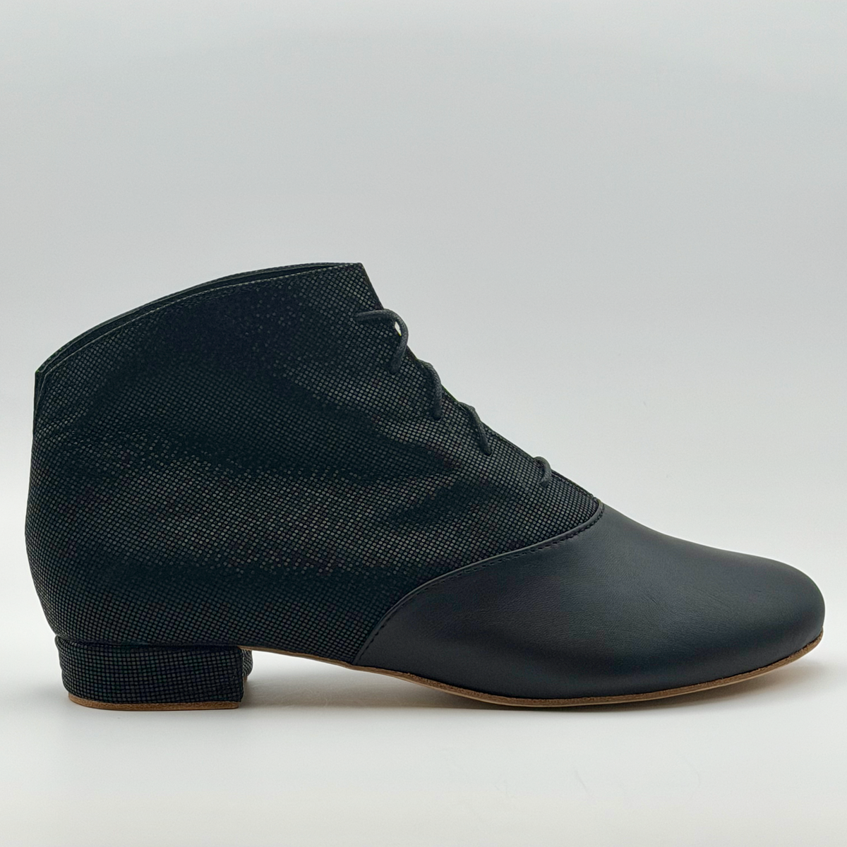 Side profile of the Mono Fumée Bottine women's tango bootie, showing the smooth black leather toe, smoky micro-dot textured upper, lace-up front, and low Cuban heel