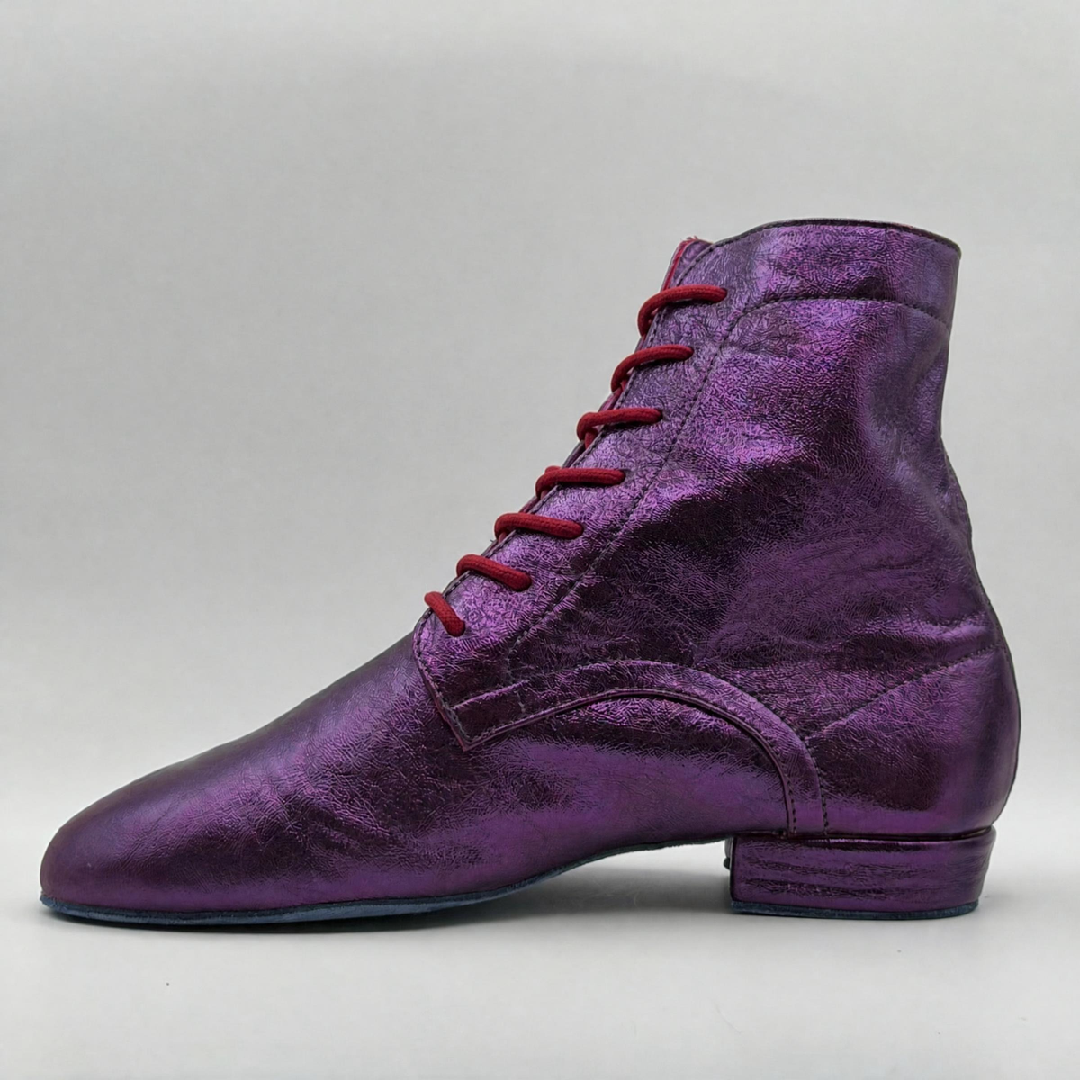 Opposite side profile of the Mono Jacarandá tango boot showing the full shaft height, the almond toe, and the metallic leather-covered heel