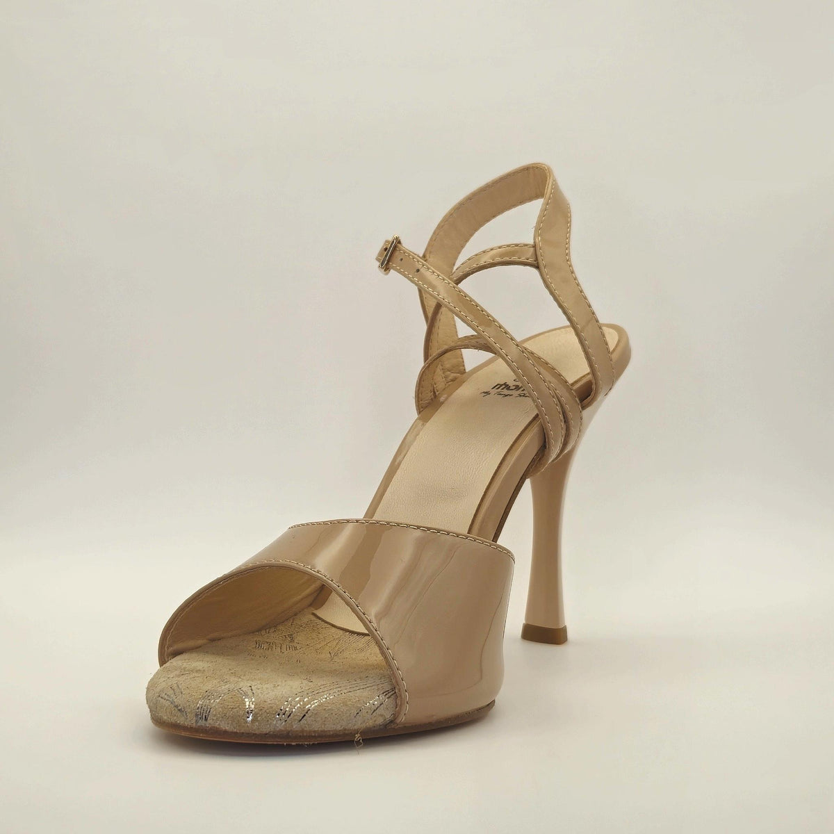Three-quarter view of Mono Porcelain Stiletto women's tango sandal facing right, showing the wrap ankle strap and porcelain patent leather upper.
