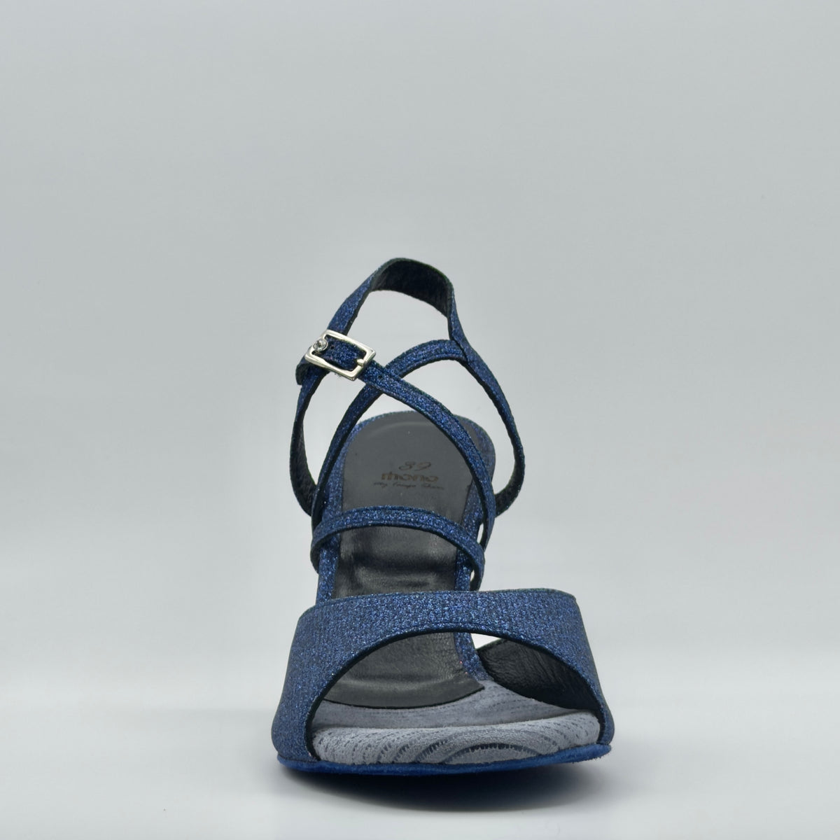 Front-facing view of the Mono Sapphire women's tango sandal, highlighting the wide peep-toe band, crossed glitter leather straps, silver buckle detail, and Mono branded insole.