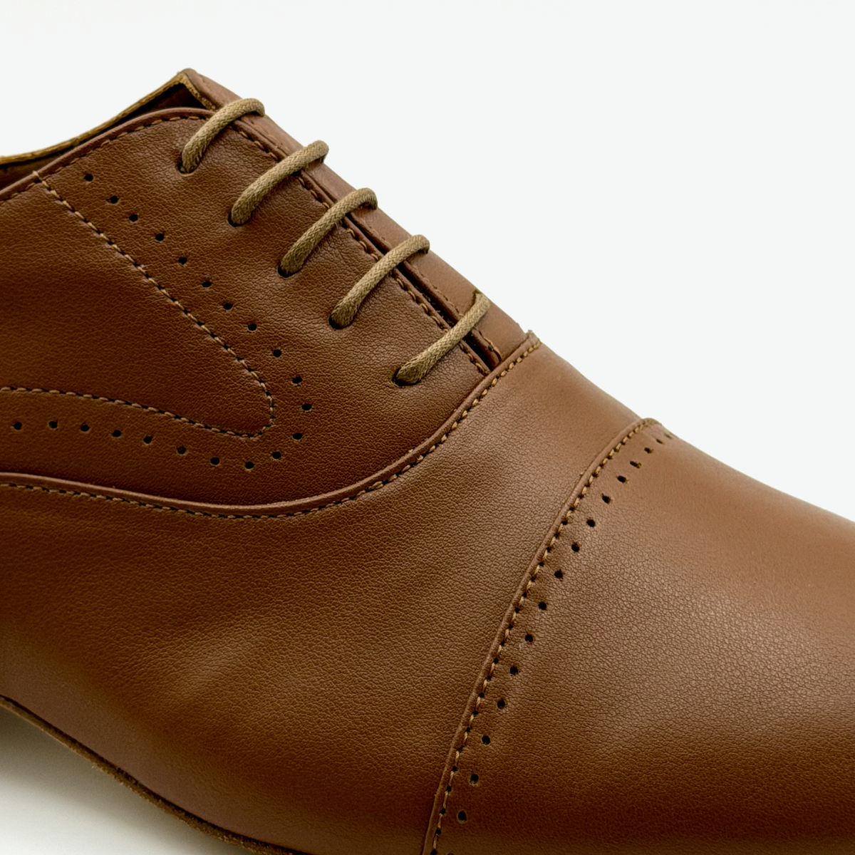 Close-up of the closed oxford lacing, tan waxed laces, and brogue perforations on the Tabacco tango shoe